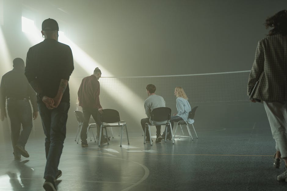 A group of diverse men sitting together in a support group, engaging in conversation and sharing their experiences related to anxiety management.