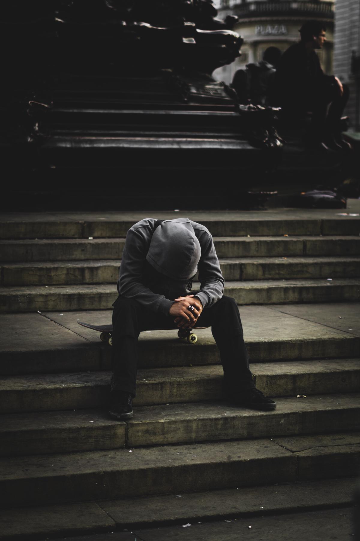 An image of a man holding his head in his hands, visually representing the weight of anxiety on male mental health