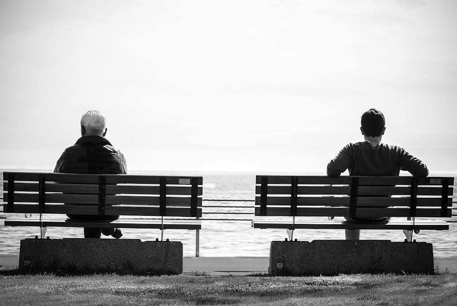 Image of a man sitting alone on a bench contemplating, representing men's mental health and the importance of self-care