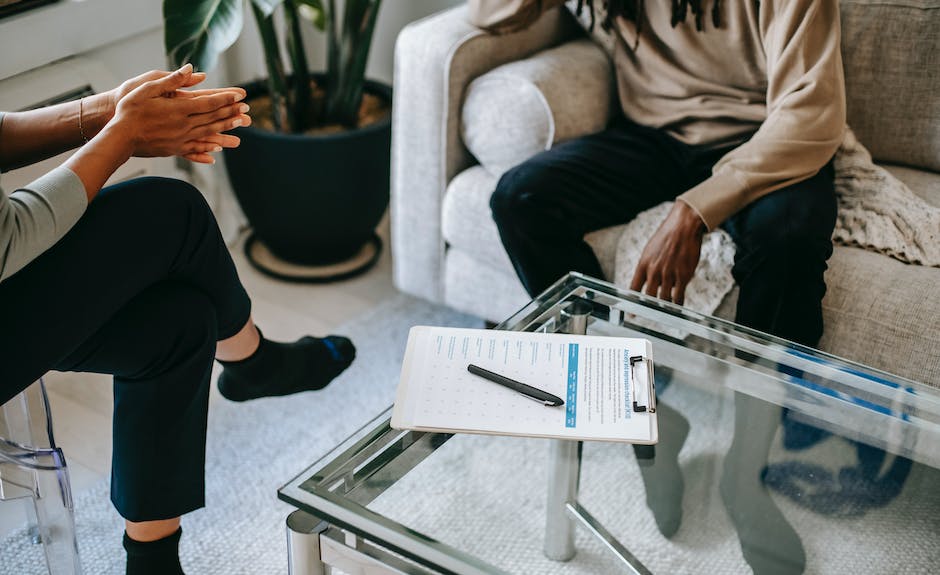 Image of a person sitting and talking with a therapist, representing the concept of therapy for mental well-being.